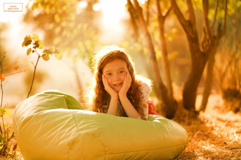 צילום רחל R Y ילדה גינגית שוכבת נשענת על הידיים